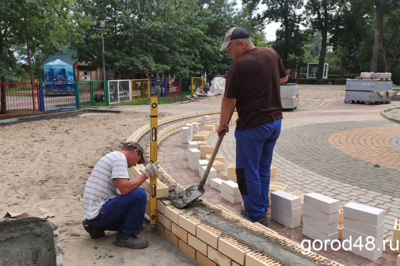 На игровой площадке в Детском парке рабочие укладывают покрытие На игровой площадке в Детском парке рабочие укладывают покрытие